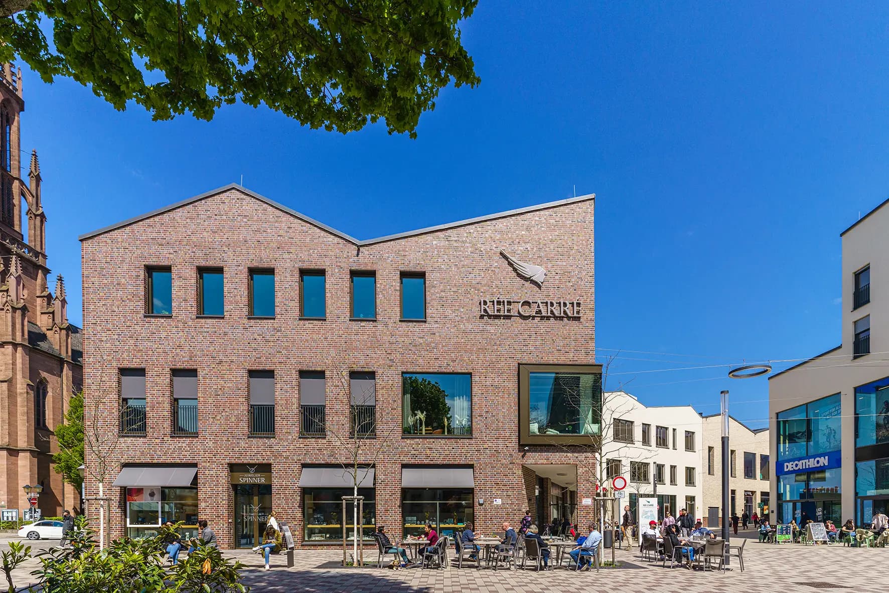 Fassade des Rée Carré mit Café-Terrasse und Quartiersplatz in Offenburg